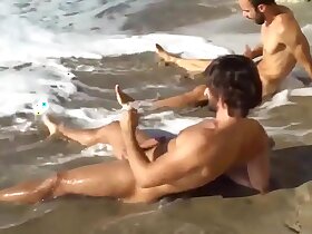 Two gay friends stroking at the beach